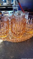 set of pink pressed glass tumblers on matching tray