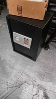 Full view of black electronic safe with silver keypad