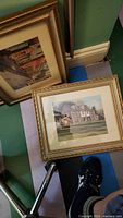 Two framed prints, gold frames with mats showing Philadelphia building and street scenes