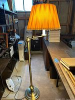Full view of brass floor lamp with pleated shade