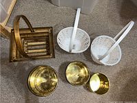 Overview of all six items on floor: two white baskets, three gold containers, one wooden basket