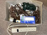 Box containing cords, adapters, GE night light, power strip