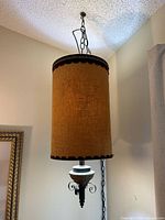 Full view of hanging burlap pendant light with chain and finial
