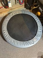 Top view of round mini trampoline showing silver padded edge and black jumping surface