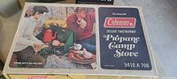 Box of Coleman deluxe two-burner propane camp stove