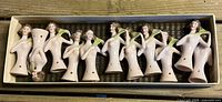 Box with 11 porcelain half dolls aligned
