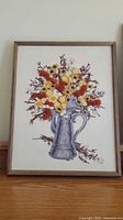Framed yarn art of pewter pitcher with wildflowers