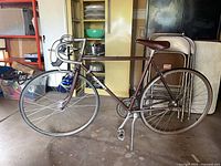 Full view of maroon Nishiki road bicycle leaning in garage