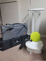 Avalon On the Move playpen packed in carrying bag, black color, with part of bed rail visible