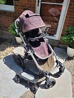 Photo of Baby Jogger City Select stroller in outdoor setting showing stroller canopy, seat, and frame with large rear and front wheels.