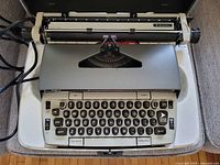 Front view of Smith-Corona Electra 220 electric typewriter inside case showing keys and platen roller.