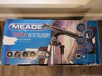 Box for Meade TeleStar DS-2076AT telescope showing product name and features with space-themed graphics.