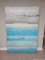 Full front view of large blue and gray abstract stretch canvas artwork hung vertically against a wall.