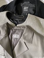 Photo showing labels of Gianfranco Ferré, Lida Baday, and Philosophy di Alberta Ferretti on jackets indicating designer brands in the lot