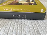 Side view of two stacked hardcover books: Vivid (yellow spine) and Best Of: 500 Timeless Interiors (black spine)