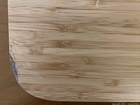 Close-up photo of bamboo desk corner showing chip in veneer.