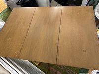 Top view of the wooden pivot top dining table showing the surface wear and hinged leaf design.