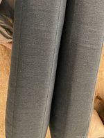 Two side-by-side dark gray cushions covered in smooth Sunbrella fabric with visible seam lines observed from a top angle.