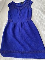 Full view of cobalt blue sleeveless dress by The Kooples laid flat showing lace details and textured fabric.