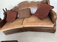 Photo of brown leather and fabric sofa with three throw pillows