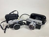 Two film cameras side by side with cases