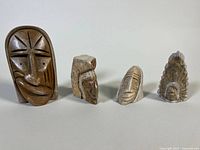 Four indigenous soapstone carvings arranged in a row showing size and diversity of styles