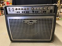 Front view showing control panel, chrome knobs, input jacks and speaker grille with Traynor badge