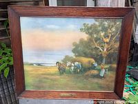 Frontal image of the framed pastoral harvest scene print showing oak frame and horses with figures in a field.