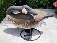 Side angle showing the carved wooden Canada goose with detailed naturalistic paint and metal stand beneath it.