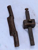 Wooden spoke shave and carpenter's scribe placed side by side on white cloth background showing overall condition and detail.