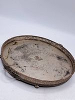 Top view showing oval silver-plated tray with pierced rim, crest, handles and heavy tarnish