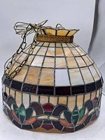 Full view of dome-shaped stained glass lampshade with chain
