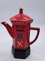 Full view of red pillar postbox teapot with lid, handle, spout, black base