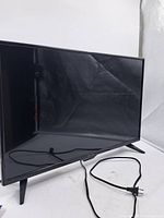 Front view of Insignia 32-inch LED TV on its feet with attached power cord