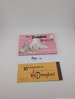 Yellow Disneyland ticket book with brown spine and vintage text showing admission for 10 adventures, priced at $3.75.