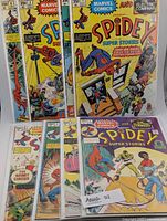 Eight Spidey Super Stories comic books numbered 1 through 8 shown, with colorful illustrated covers featuring Spider-Man and other characters, published by Marvel Comics with The Electric Company branding. Some comics show white stickers and some signatures.