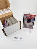 Box with approximately 100 baseball cards and Eric Davis card in protective sleeve displayed on a stand.