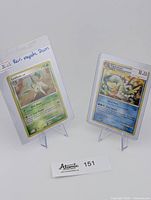 Two Pokemon cards displayed upright on stands, Leafeon on left and Vaporeon on right, with price tags visible.