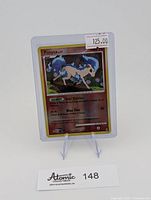 Card displayed upright in top-loader on stand showing front and sleeve