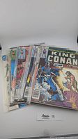 Eight vintage Marvel comic books shown in a stack with the King of Conan cover visible.