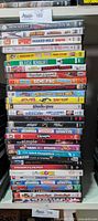 Stack of 30 comedy movie DVDs showing colorful spines with titles clearly readable.