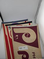 Stack of vintage MLB team pennants with partially visible designs and colors, indicating multiple teams.