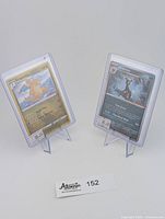 Two Pokemon promotional cards displayed on clear plastic stands: Dragonite holo card and Umbreon non-holo card, with price tags $20 and $25 respectively.