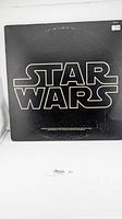Front cover of the vinyl record with large Star Wars logo in white on black background.