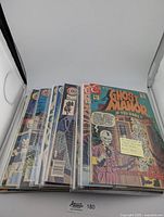 Front view of 18 vintage horror comic books in protective sleeves, showing colorful illustrated covers with spooky themes.