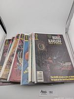 Stack of fourteen vintage Boris Karloff Tales of Mystery comics in clear protective sleeves, showing various colorful illustrated covers