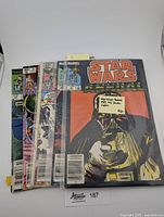 Five vintage Star Wars Marvel comic books fanned out, covers visible, in protective sleeves. Featuring Star Wars Annual 1983 #3 with Darth Vader on cover plus four additional Star Wars titles.