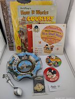 Photo showing the glass bowl, pins, books, and one 45 RPM record with storybook