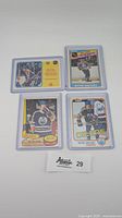 Four Wayne Gretzky hockey cards laid out on white surface, showing fronts and backs with protective card sleeves.