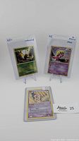 Three Pokémon cards set up on display stands: Scyther (green card, reverse holo), Smoochum (purple-black star promo holo), and Mime Jr. (purple-black star promo holo) in protective sleeves.